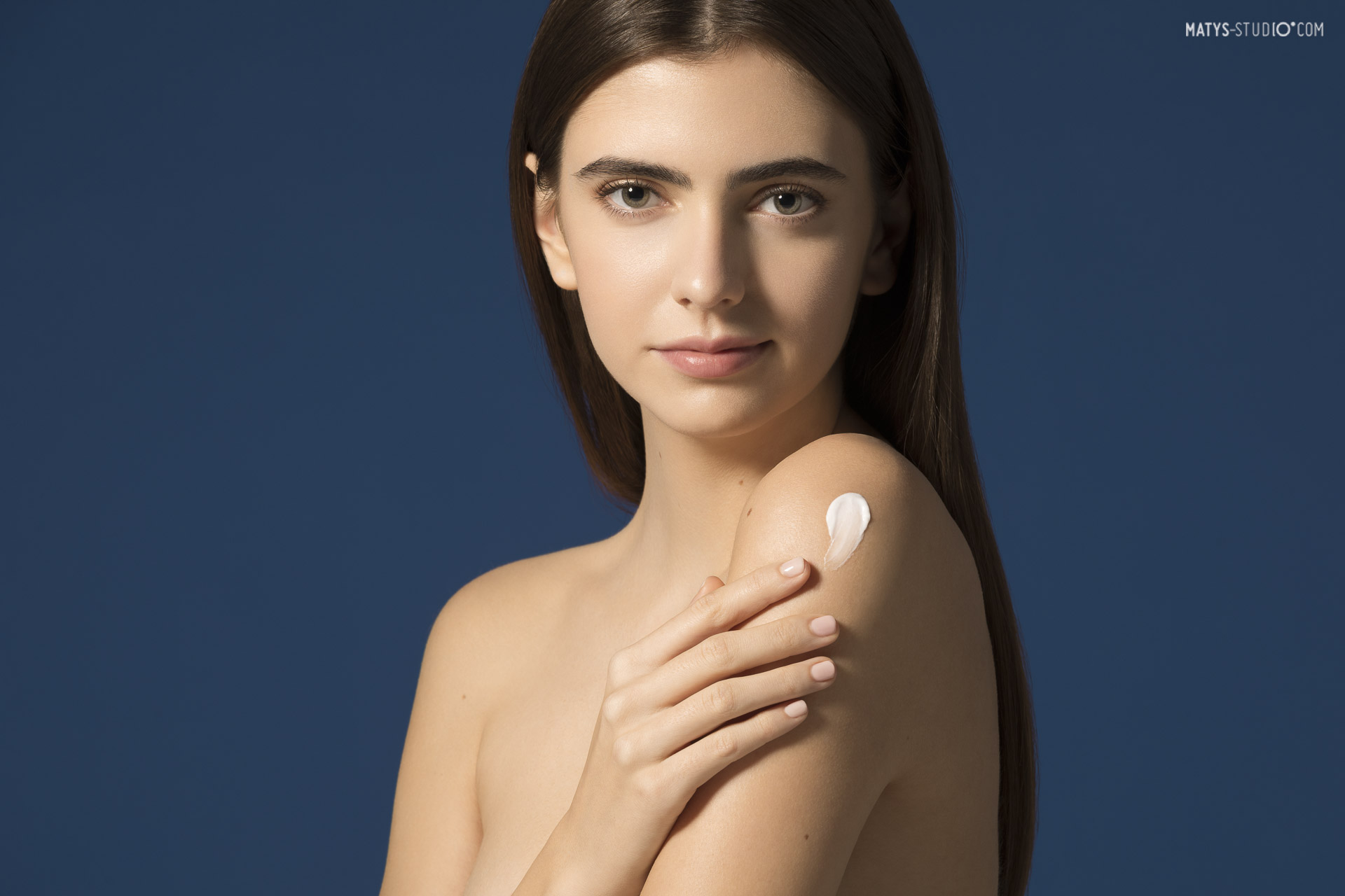 modelka prezentująca na ramieniu krem przeciwsłoneczny Dermedic podczas sesji beauty