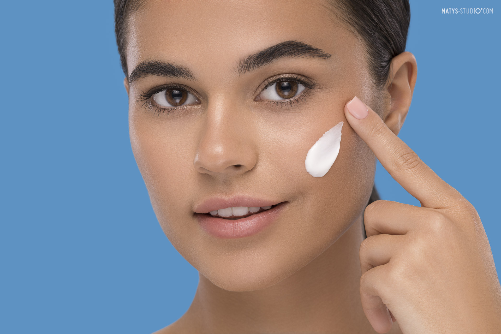 zdjęcie reklamowe kremu Dermedic nakładanego na twarz modelki